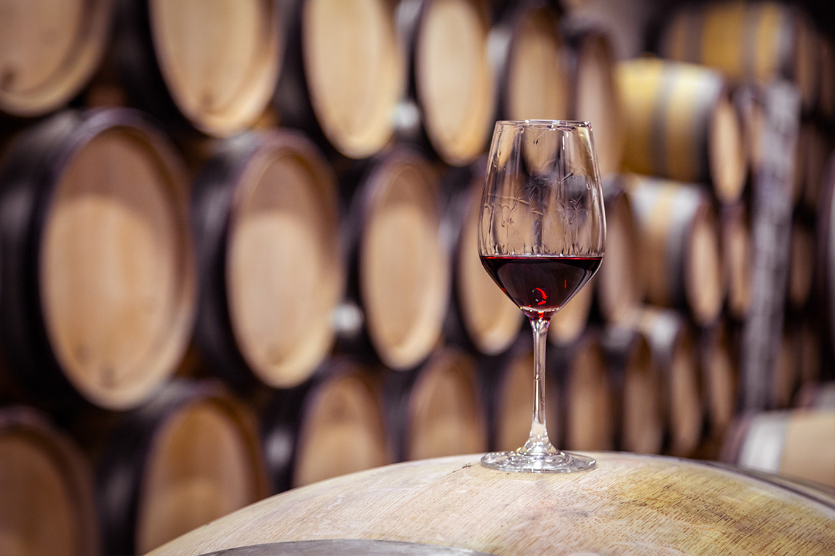 Glass of Burgundy wine resting on a barrel